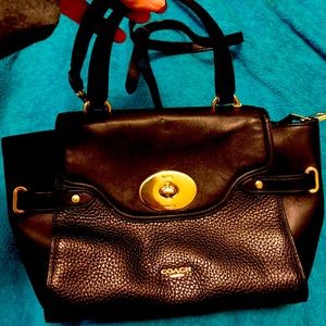 Medium Coach purse with handles to carry it and a strap to wear it crossbody.